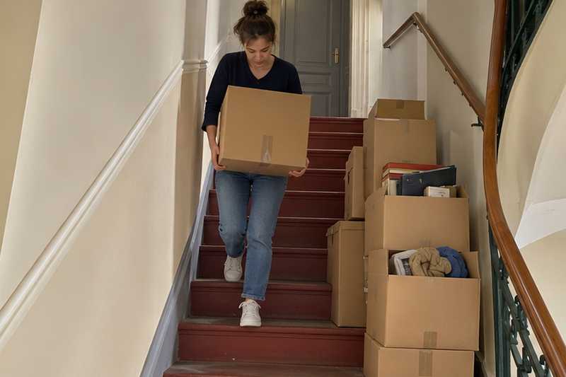 Cartons légers de vêtements et de livres dans un escalier étroit