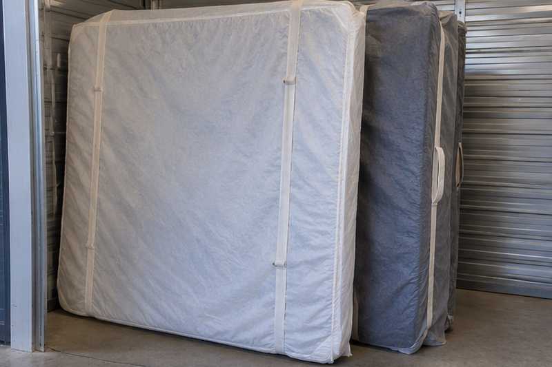 Matelas et sommier sous housses respirantes debout en stockage