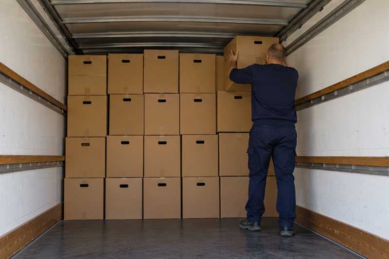 Cartons de livres calés au fond d'une caisse de camion