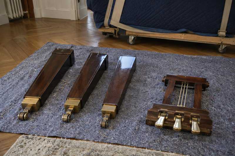 Pieds démontés d'un piano demi-queue posés sur une couverture