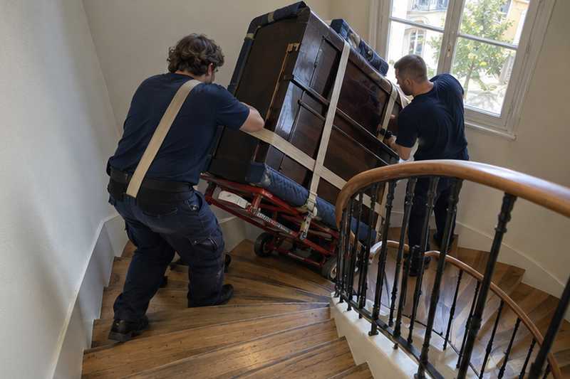 Piano droit monté sur luge dans un escalier tournant